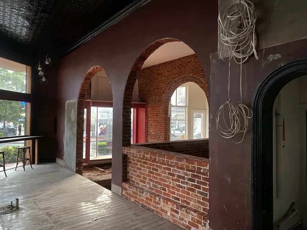 The room looking toward Clarinda Street, brick archways and a low brick wall with the shopfront doors beyond